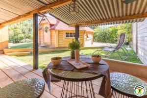a patio with a table and chairs on a deck at Le Cocon des Cinq Sens - l'Insolite in Haute-Goulaine