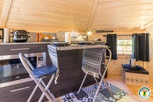 a kitchen with a table and chairs in a cabin at Le Cocon des Cinq Sens - l'Insolite in Haute-Goulaine