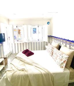 a bedroom with a large bed with white sheets and pillows at Zenit Olhao baixa one bedroom house sea side view in Olhão