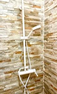 a white shower head on a brick wall at Zenit Olhao baixa one bedroom house sea side view in Olhão