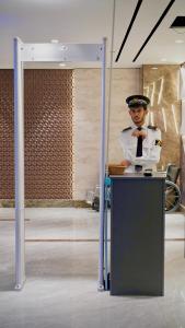 a man in uniform is standing behind a desk at Executive 2BHK in Zeta Mall in Islamabad +62 photos