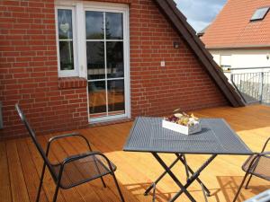 a table with a bowl of fruit on a patio at Ferienwohnung-Sonnenterrasse in Malchow