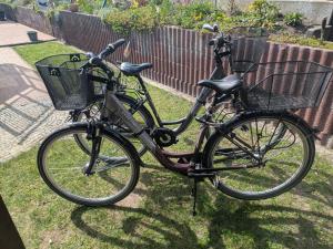 a bicycle with a basket parked in the grass at Ferienwohnung-Sonnenterrasse in Malchow