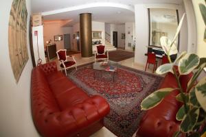 a living room with a leather couch and a table at Hotel Massimino in Anguillara Sabazia
