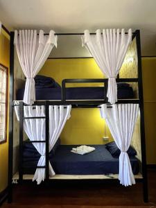 a bunk bed room with two bunk beds with curtains at Pakse Chill Hostel in Pakse