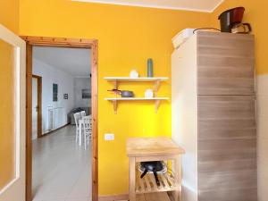 a yellow room with a table and a yellow wall at M274 - Marcelli, comodo quadrilocale vista mare con terrazzo in Marcelli +19 photos