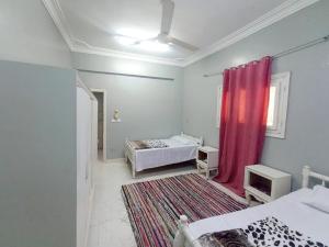 a room with two beds and a red curtain at Winji Guest house in Aswan