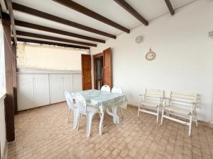 a dining room with a table and white chairs at M274 - Marcelli, comodo quadrilocale vista mare con terrazzo in Marcelli