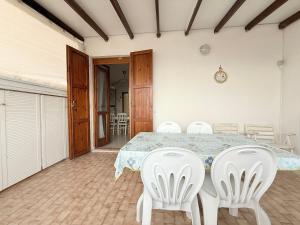 a dining room with a table and white chairs at M274 - Marcelli, comodo quadrilocale vista mare con terrazzo in Marcelli