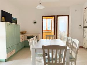 a kitchen with a table and chairs in a room at M274 - Marcelli, comodo quadrilocale vista mare con terrazzo in Marcelli