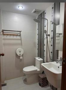 a white bathroom with a toilet and a sink at HOÀNG ĐẾ motel in Chau Doc