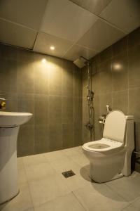 a bathroom with a toilet and a sink at Regal Peninsula Hotel Formerly New Peninsula Hotel Ghubaiba Bus Station Bur Dubai in Dubai +12 photos