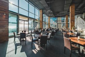 a dining room with tables and chairs and windows at Avala Resort & Villas in Budva