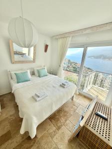 a bedroom with a large bed with a large window at Feraye Villas in Kaş