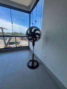 a black fan in a room with a window at Espaço Viva Guarujá in Guarujá