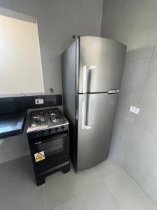 a stainless steel refrigerator in a kitchen with a stove at Espaço Viva Guarujá in Guarujá