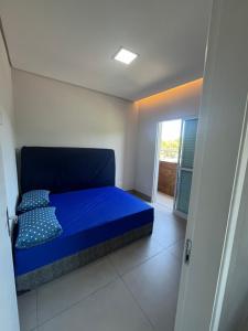 a blue bed in a room with a window at Espaço Viva Guarujá in Guarujá +22 photos