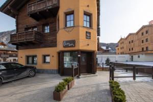 ein Gebäude, vor dem ein Auto geparkt ist in der Unterkunft Chalet Layla by Original Galli in Livigno