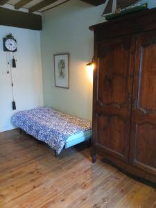 a bedroom with a bed and a large wooden cabinet at au coin perdu in Lauzerte