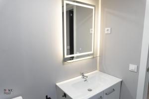 a white bathroom with a sink and a mirror at Sierra de Madrid Suites in Galapagar +10 photos