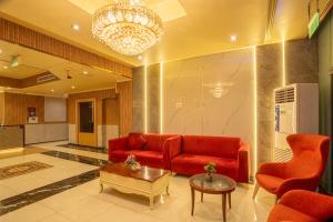 a living room with a red couch and a table at Regal Peninsula Hotel Formerly New Peninsula Hotel Ghubaiba Bus Station Bur Dubai in Dubai