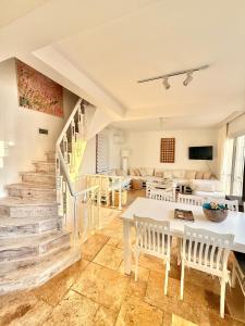 a living room with a staircase and a table and chairs at Feraye Villas in Kaş