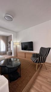 a living room with a couch and a tv at Casa Luxemburgo in Torrevieja