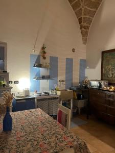 a kitchen with a table and a kitchen with a counter at Zen Palazzo Storico in Alliste +22 photos
