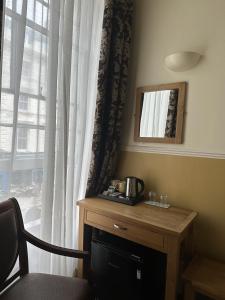 a room with a table and a window with a coffee maker at The Lindum in Hastings