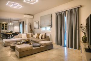a living room with a couch and a table at Daedalus Luxury Home - Seaview & Heated Pool in Kontokali +78 photos