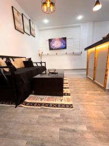 a living room with a black couch and a table at Dar el bahdja in Sidi MʼHamed