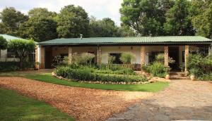 a house with a garden in front of it at Honey Farm Country Get Away in Skeerpoort