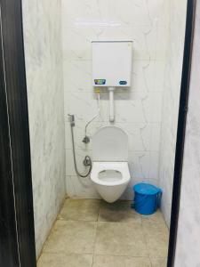 a bathroom with a toilet with a water tank at Abuzz Oxfordcaps Simla in Shimla +14 photos