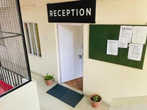 a room with a door and a sign that reads reception at Abuzz Oxfordcaps Simla in Shimla