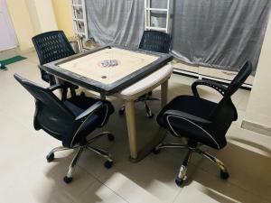 a ping pong table and two chairs in a room at Abuzz Oxfordcaps Simla in Shimla