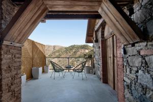 a patio with chairs and a table with a view at Lyhnos in Askas