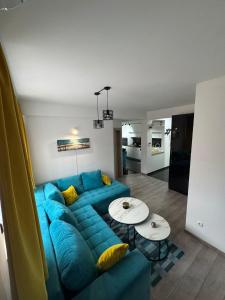 a living room with a blue couch and two tables at Apartman "Park" in Livno