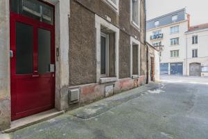 a red door on the side of a building at suite Tirelire, centre et paisible in Reims