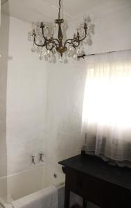 a bathroom with a chandelier and a bath tub at Honey Farm Country Get Away in Skeerpoort +36 photos
