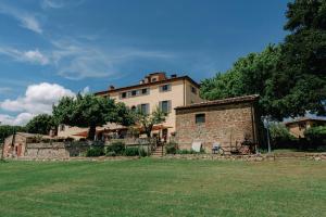 a large building in front of a grass field at Terre di Nano in Monticchiello