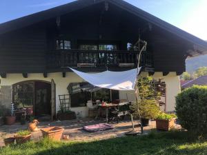 a house with a patio with a table and a balcony at Seelenbaumlerin in Schliersee