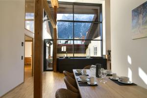 a dining room with a table and chairs and a large window at Adlerhorst -410- in Mittenwald