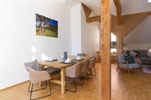 a dining room with a wooden table and chairs at Adlerhorst -410- in Mittenwald