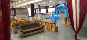 a waiting room with chairs and a blue arch at Hotel Bhabha in Rajkot