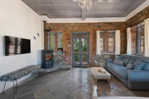 a living room with a blue couch and a fireplace at Lyhnos in Askas