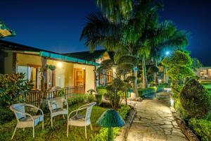 a house with chairs on the front yard at night at Corbett Nirvana Resort in Amgarhi +62 photos