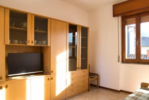 a living room with a tv in a wooden cabinet at Cuor di Barzio P1 in Barzio