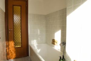 a bathroom with a bath tub and a wooden door at Cuor di Barzio P1 in Barzio +23 photos