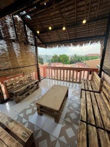 a patio with wooden benches on a roof at Maison meublée Odza Yaoundé in Yaoundé