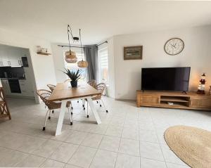 a living room with a table and a flat screen tv at Sielkate in Dornum